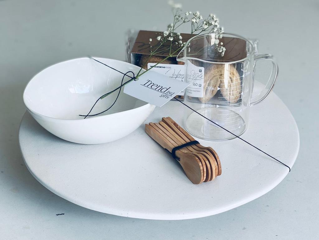 Trend{ING} Bakers Delight Baking Gift box, featuring a ceramic cake stand , glass measuring cup, wooden spoons and crunchy palmier biscuits
