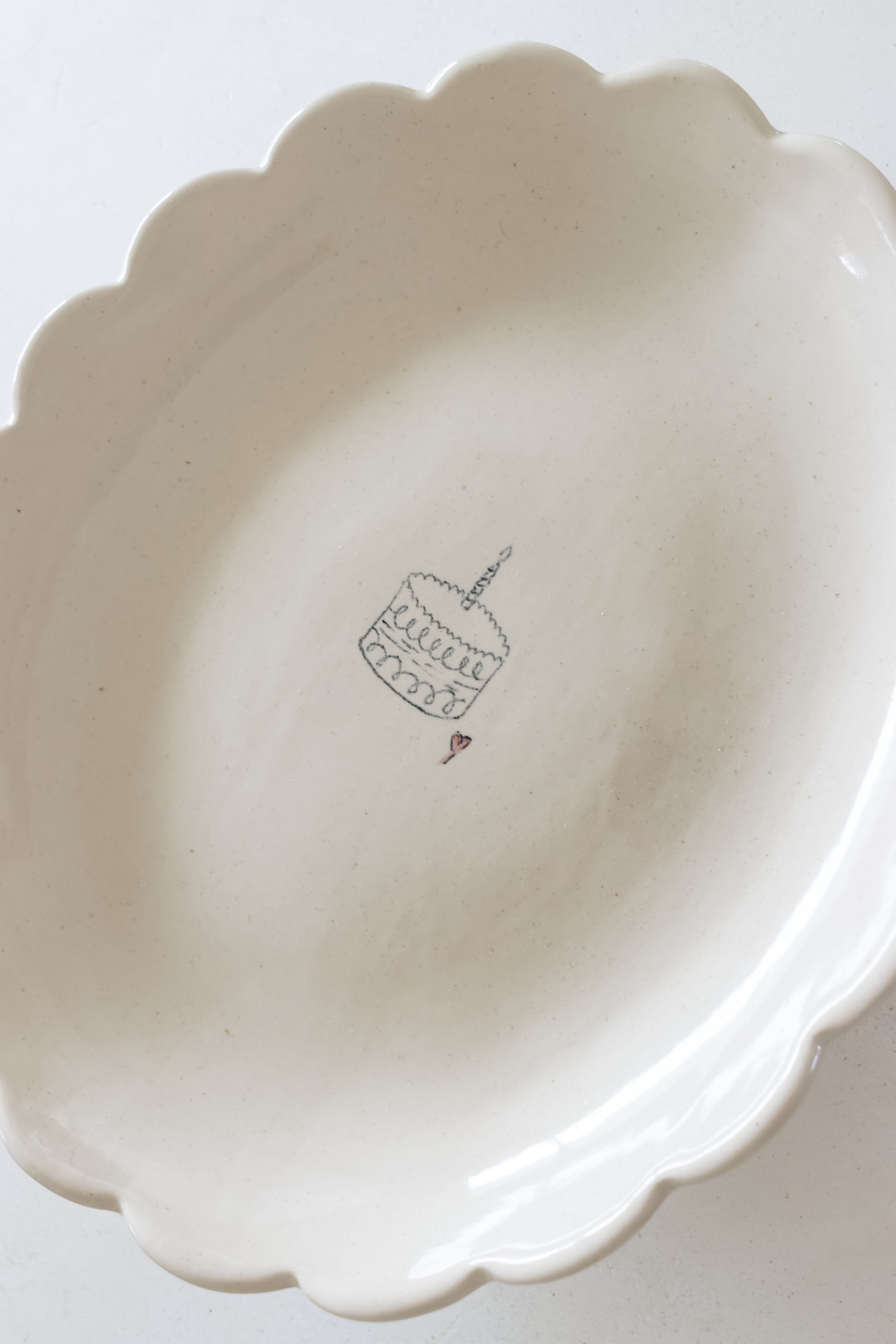 White ceramic pie dish with scalloped edge on a white background