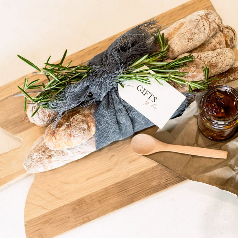 Bread and jam set on a wooden board with a gift tag, on a light background