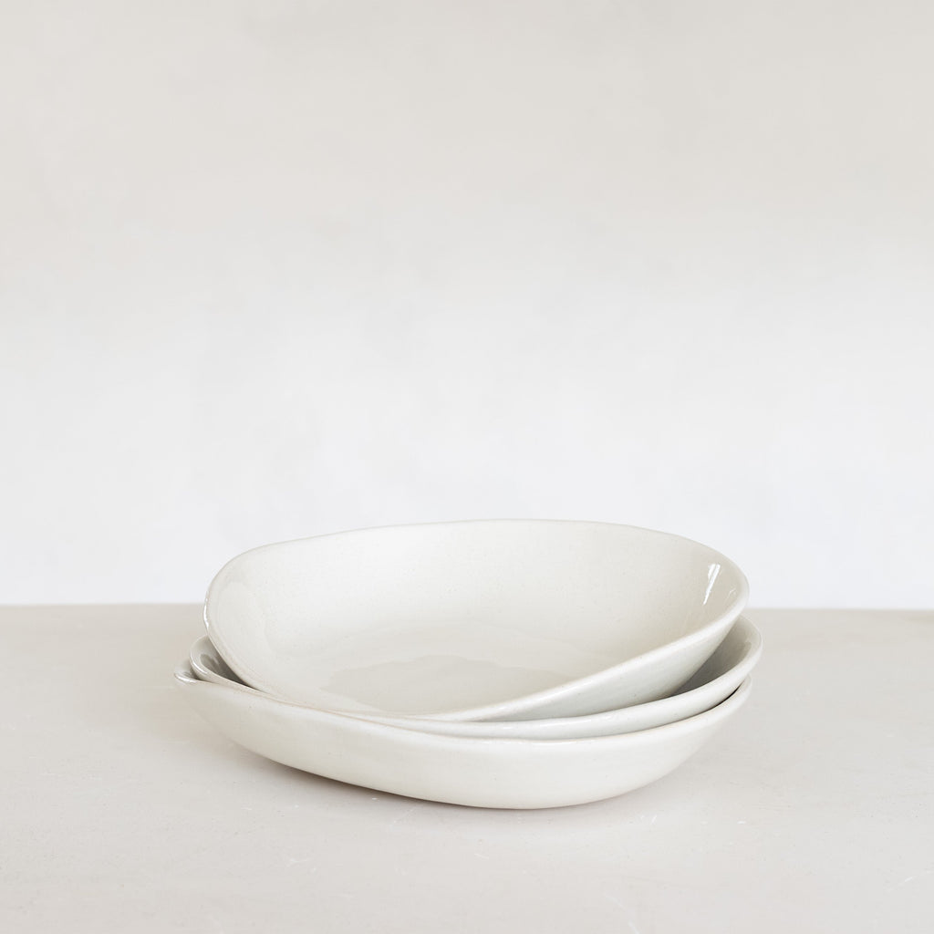 Two white ceramic bowls stacked on a light gray surface with a white background