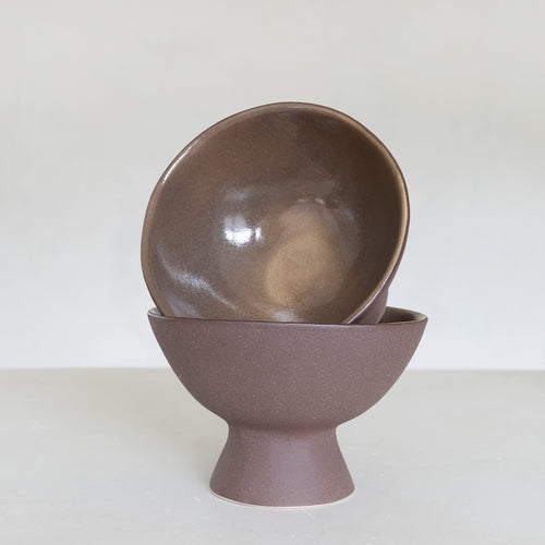 Brown ceramic bowl stacked on a matching stand against a white background