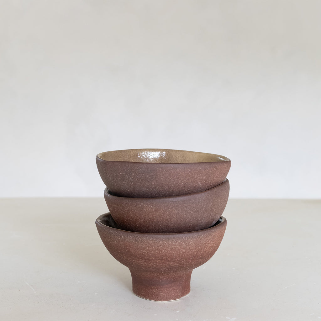 Stack of three ceramic bowls on a white background