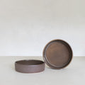 Two ceramic bowls on a white surface with a plain background