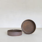 Two ceramic bowls on a white surface with a plain background