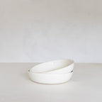 White ceramic bowl on a light gray surface with a white background