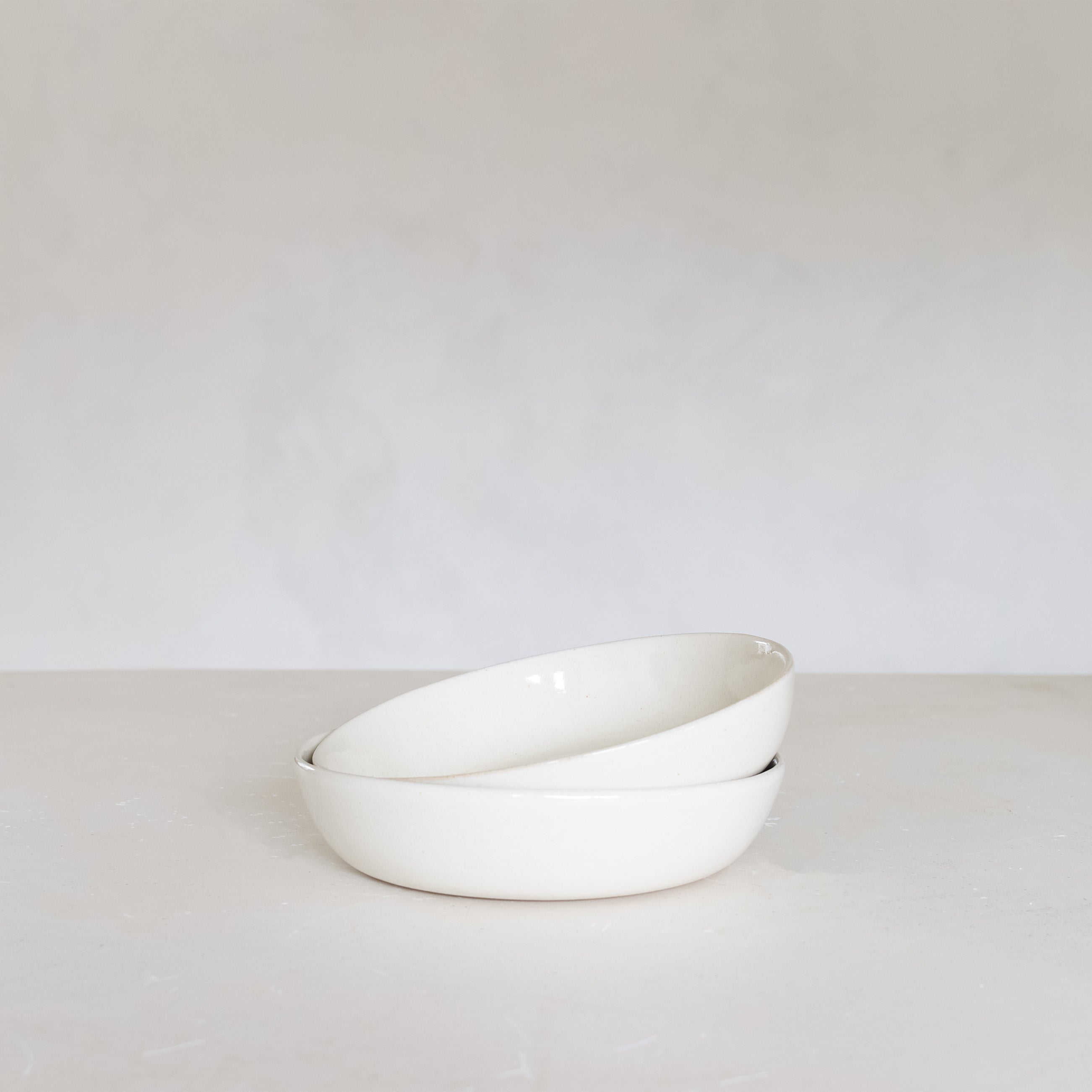 White ceramic bowl on a light gray surface with a white background