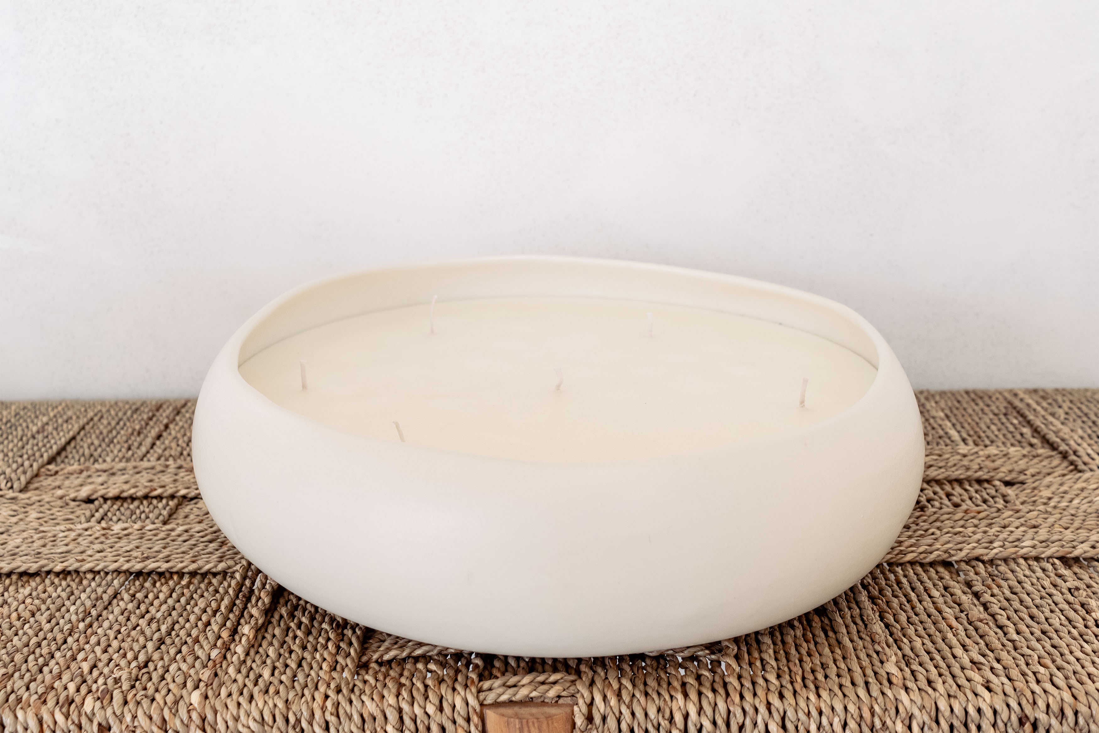 XL 5 wick wonky candle on a woven bench