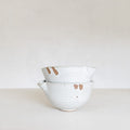 Set of ceramic bowls with brown speckles on a white surface and background