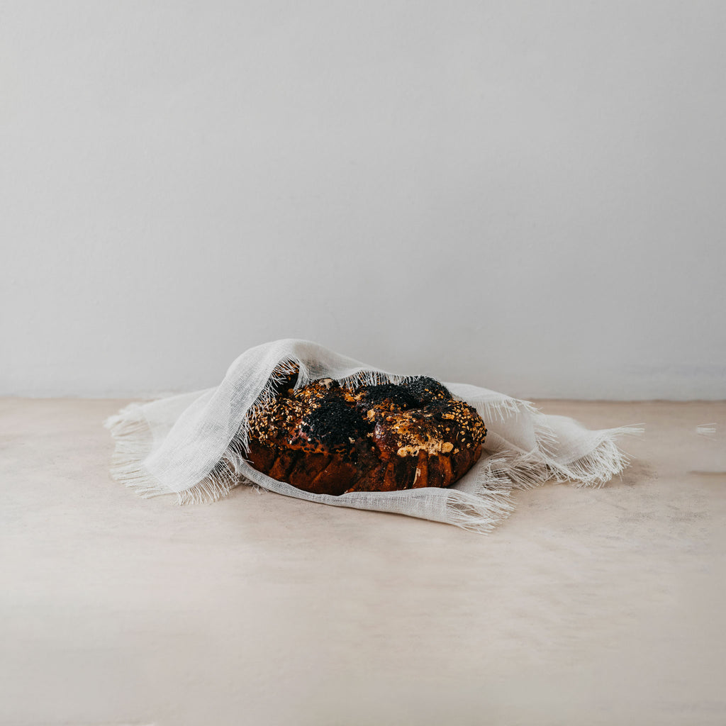 Trend{ING}s Linen Challah/Bread Cover in white; freshly baked challah bread inside